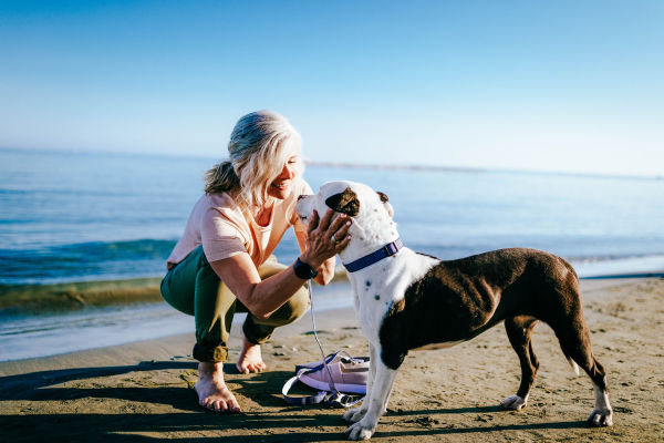 Frau mit Hund am Strand - Geheimtipps Ostsee