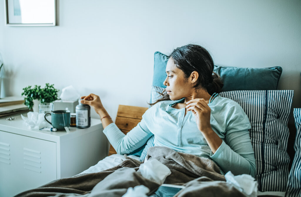 Frau liegt krank im Bett 