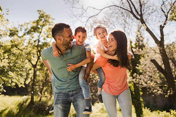 Familie mit zwei Kindern im Garten als Zielgruppe für Ferienunterkünfte